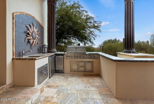 view of patio featuring an outdoor kitchen, sink, and a grill