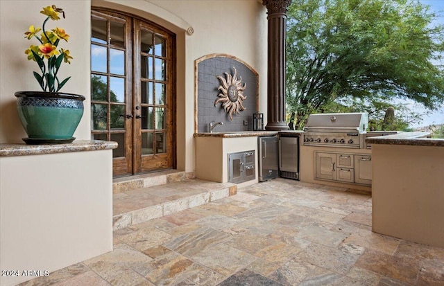 view of patio / terrace with area for grilling, a grill, and french doors