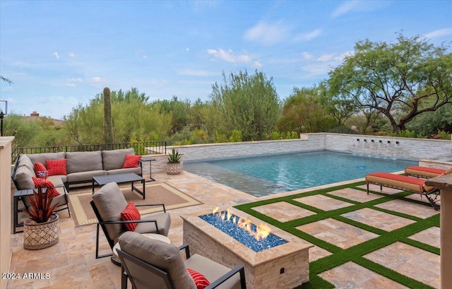 view of pool featuring an outdoor living space with a fire pit and a patio