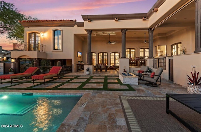 rear view of property with a patio area, ceiling fan, stucco siding, french doors, and a fenced in pool