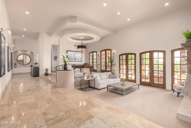 living room with recessed lighting, french doors, a high ceiling, and baseboards