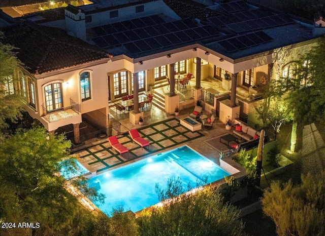 exterior space with a patio area, a balcony, french doors, and an outdoor pool