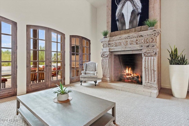 living area featuring french doors, carpet floors, and a warm lit fireplace