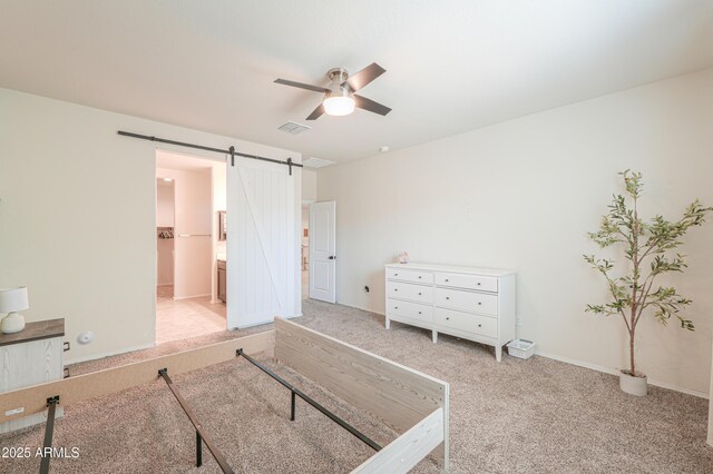 36467 W Pampoloma Ave, Maricopa, AZ 85138 - unfurnished bedroom featuring carpet flooring, a barn door, a ceiling fan, baseboards, and ensuite bath