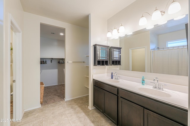 36467 W Pampoloma Ave, Maricopa, AZ 85138 - full bath with double vanity, tile patterned floors, a walk in closet, and baseboards