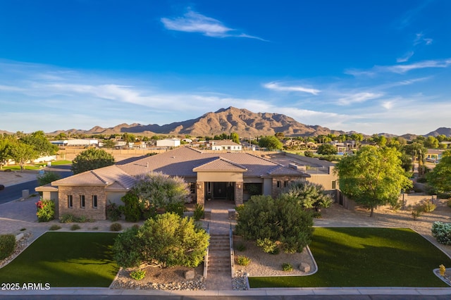 view of front of house with a mountain view and a front yard