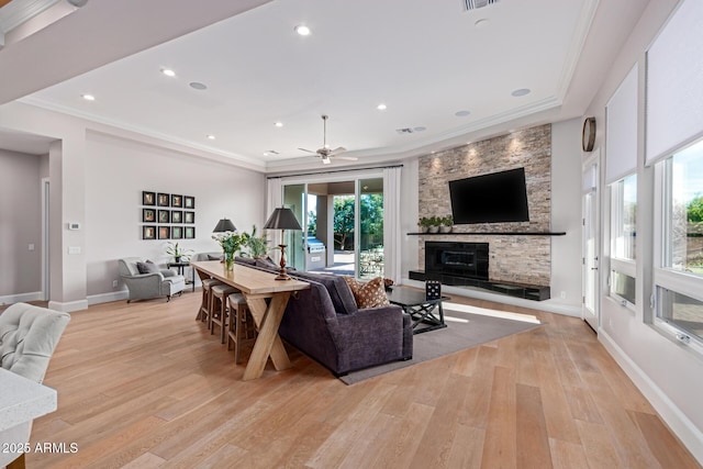 living room featuring a fireplace, light hardwood / wood-style flooring, and ornamental molding