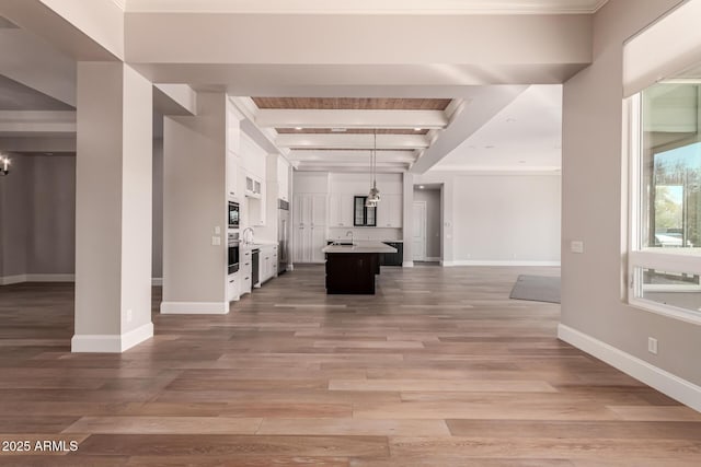 interior space with hardwood / wood-style flooring, beam ceiling, and sink