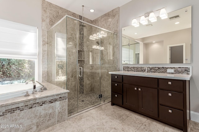 bathroom with vanity, decorative backsplash, and plus walk in shower