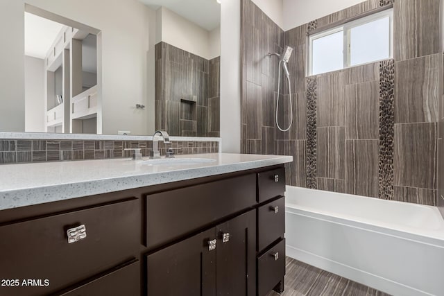 bathroom with vanity, tiled shower / bath combo, and tasteful backsplash