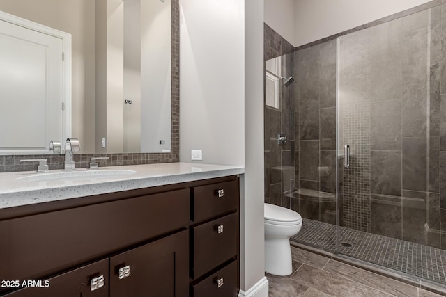 bathroom featuring a shower with door, vanity, and toilet