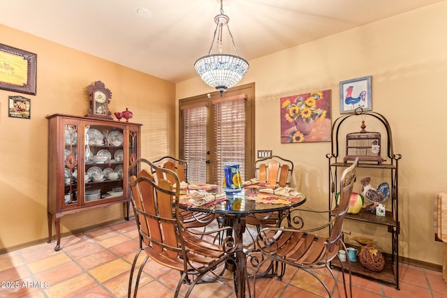 dining area featuring a chandelier and baseboards