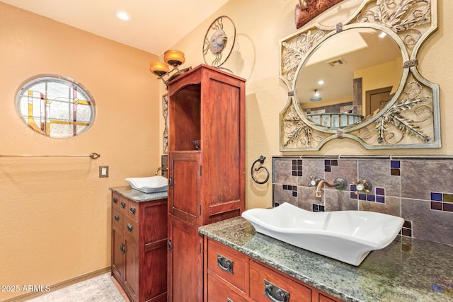 bathroom featuring visible vents, baseboards, tasteful backsplash, and vanity