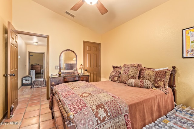 bedroom featuring ceiling fan, visible vents, light tile patterned flooring, and vaulted ceiling