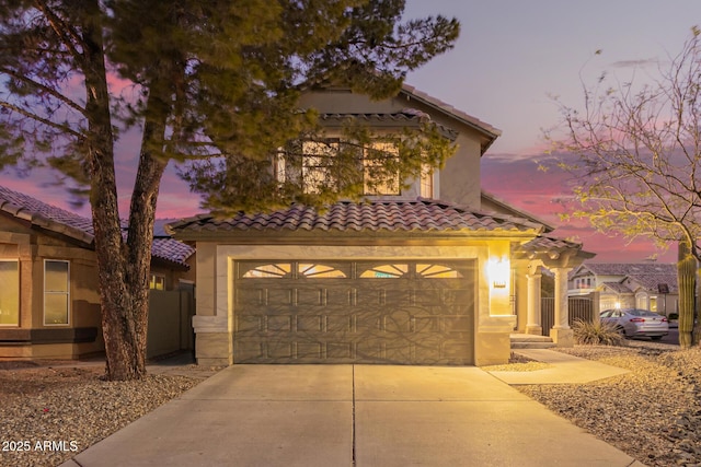 view of front of home with a tiled roof, stucco siding, and driveway