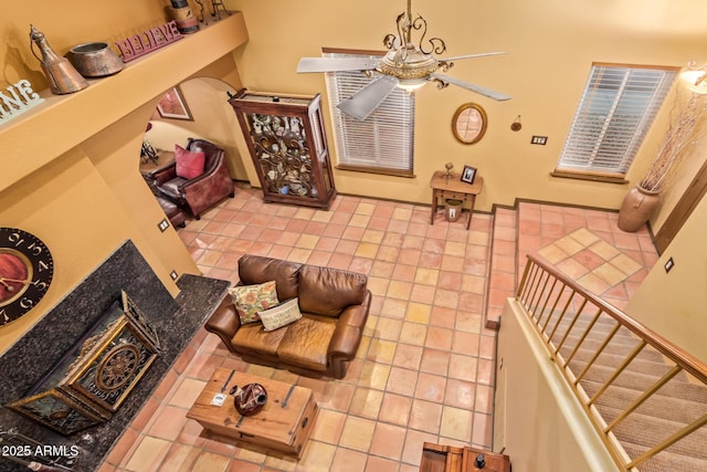 tiled living area featuring stairs and ceiling fan