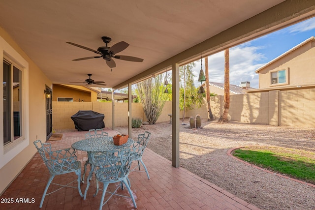 view of patio featuring a fenced backyard, area for grilling, outdoor dining space, and ceiling fan