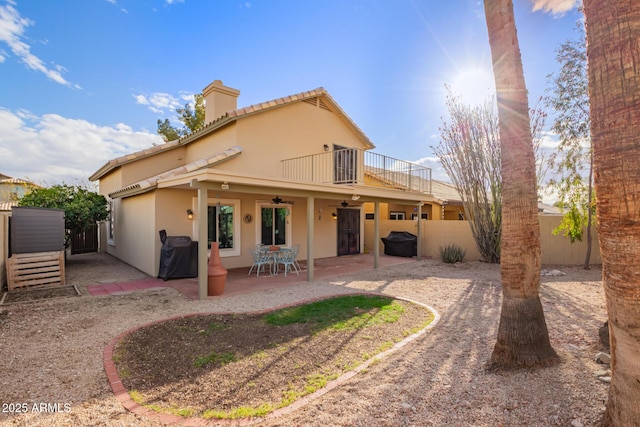 rear view of property with fence, a tiled roof, stucco siding, a patio, and a ceiling fan