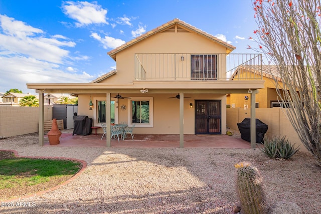 rear view of property featuring ceiling fan, a patio, a balcony, and fence