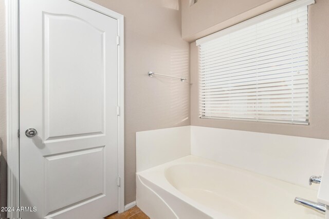 bathroom with tile patterned floors and a bathtub