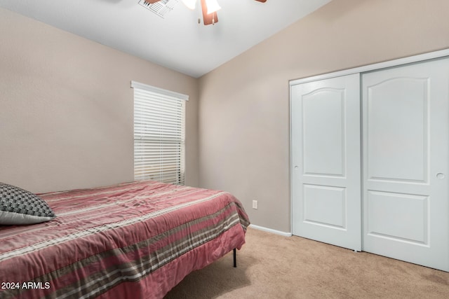 carpeted bedroom featuring ceiling fan, a closet, and lofted ceiling