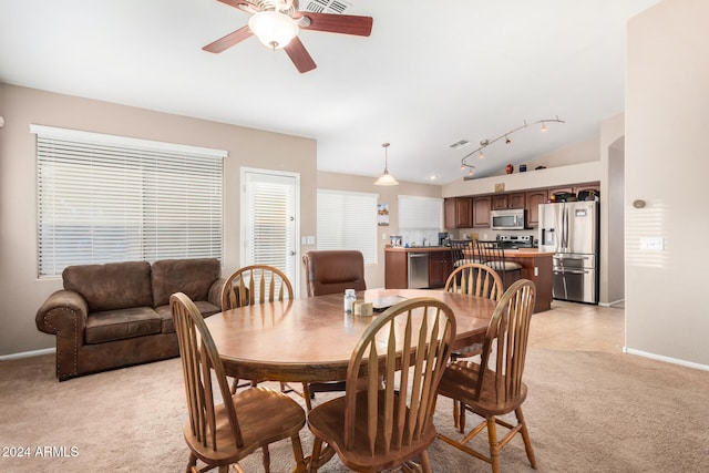 dining area with ceiling fan, light colored carpet, and lofted ceiling