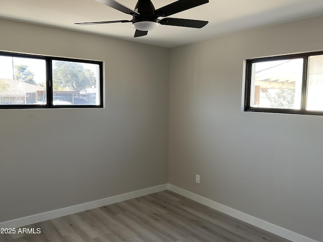 unfurnished room with wood finished floors, baseboards, a wealth of natural light, and ceiling fan