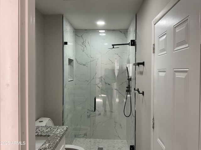 bathroom with a marble finish shower, toilet, and vanity