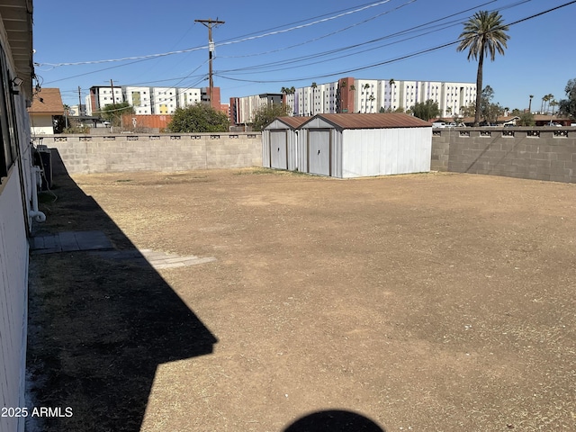 view of yard with an outbuilding, a storage shed, and a fenced backyard