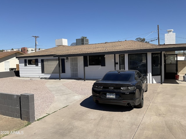 view of front of house with central air condition unit, a chimney, and a shingled roof