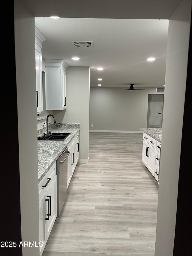 kitchen with visible vents, dishwasher, light wood-style floors, a ceiling fan, and a sink