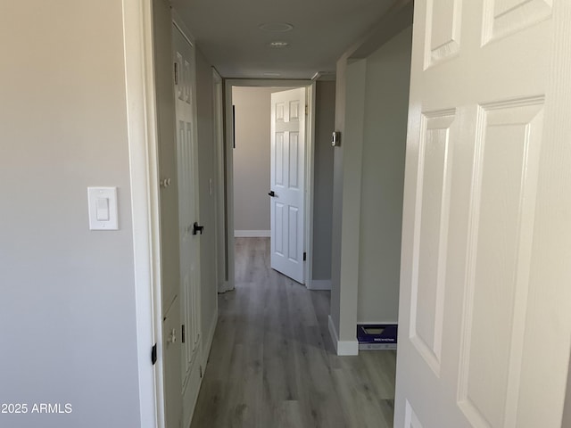 corridor with baseboards and light wood-style flooring