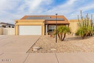 view of front of home featuring a garage and solar panels