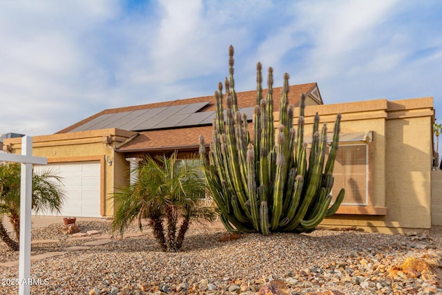 view of front of house featuring a garage and solar panels