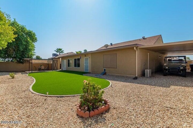 back of property featuring a yard, a carport, and central AC unit