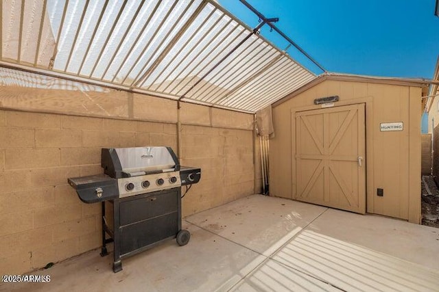 view of patio / terrace featuring a grill and a shed