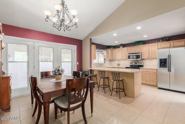 dining area with vaulted ceiling, light tile patterned flooring, and a notable chandelier