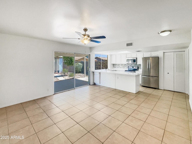 920 E Garnet Ave, Mesa, AZ 85204 - kitchen with appliances with stainless steel finishes, white cabinets, backsplash, a ceiling fan, and light countertops