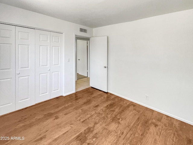 920 E Garnet Ave, Mesa, AZ 85204 - unfurnished bedroom with wood finished floors, a closet, and baseboards
