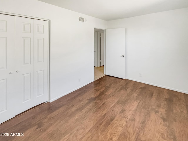920 E Garnet Ave, Mesa, AZ 85204 - unfurnished bedroom featuring wood finished floors, a closet, and baseboards