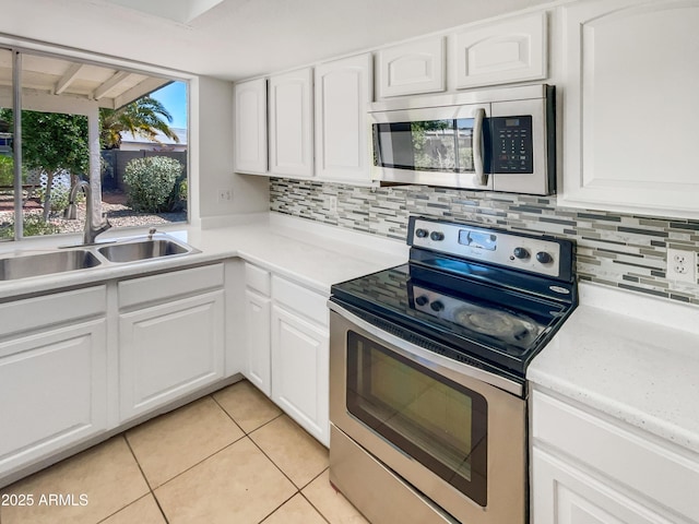 920 E Garnet Ave, Mesa, AZ 85204 - kitchen featuring stainless steel appliances, a sink, light tile patterned floors, tasteful backsplash, and white cabinetry