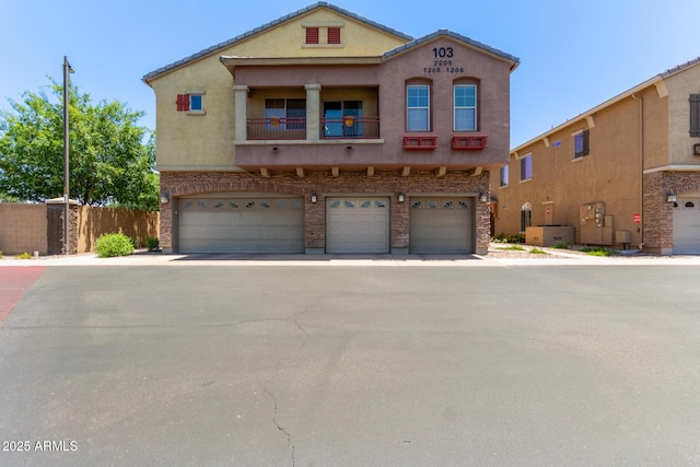1350 S Greenfield Rd Unit 2205, Mesa, AZ 85206 - view of front facade featuring a garage, stucco siding, fence, and a balcony
