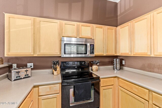 1350 S Greenfield Rd Unit 2205, Mesa, AZ 85206 - kitchen with stainless steel microwave, black electric range oven, light brown cabinetry, and light countertops