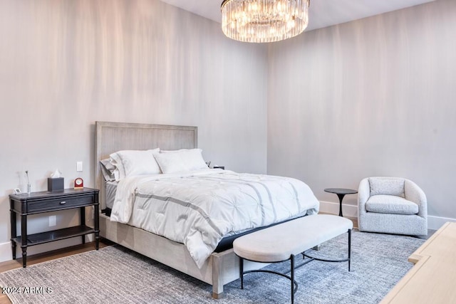 bedroom with hardwood / wood-style floors and an inviting chandelier