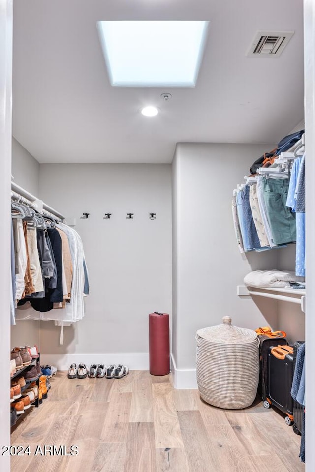 spacious closet featuring a skylight and light wood-type flooring