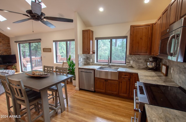 5120 N Juniper Loop, Pine, AZ 85544 - kitchen with appliances with stainless steel finishes, decorative backsplash, light wood-style flooring, and vaulted ceiling with skylight