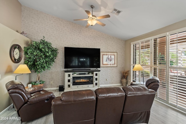 living room with light hardwood / wood-style floors, lofted ceiling, and ceiling fan