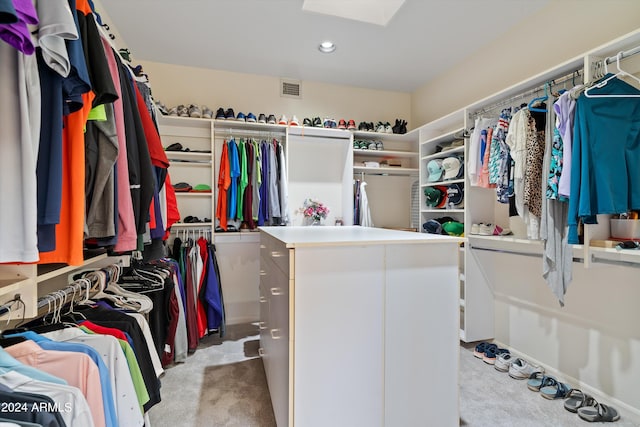 walk in closet featuring light colored carpet