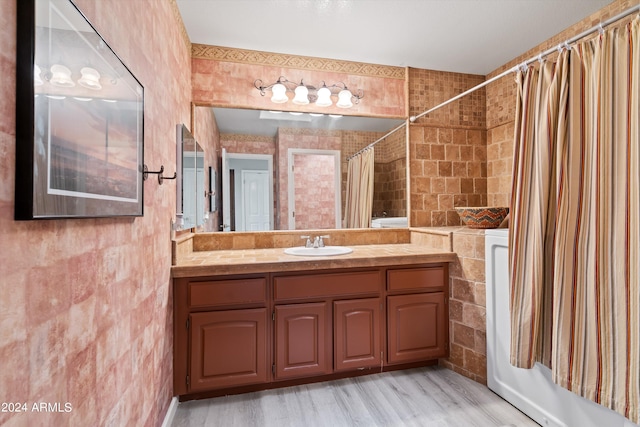 bathroom featuring vanity, shower / bath combo, wood-type flooring, and tile walls