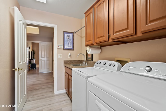 washroom with separate washer and dryer, cabinets, sink, and light wood-type flooring